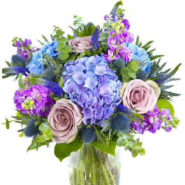 Blue and purple mixed bouquet in a clear glass vase