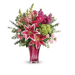 Pink and magenta floral arrangement in a tall glass vase