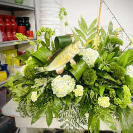 Large green floral arrangement with white blooms and a fish centerpiece