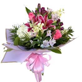 Pink and white mixed bouquet wrapped in lavender paper with a pink ribbon
