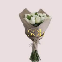 Bouquet of white roses wrapped in brown paper