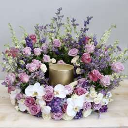 Pink and white floral wreath around a gold candle holder