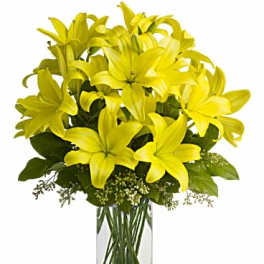 Yellow lilies arranged in a clear glass vase