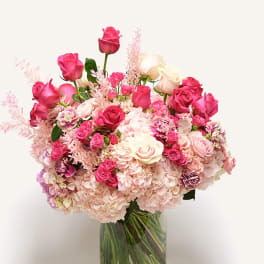 Pink and white rose bouquet in a clear glass vase