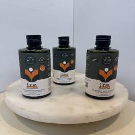 Three plant care bottles on a round white pedestal