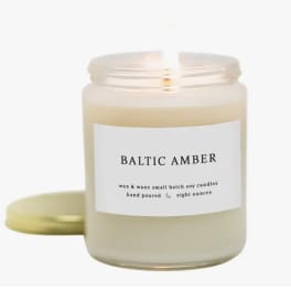 A scented candle in a glass jar with a gold lid