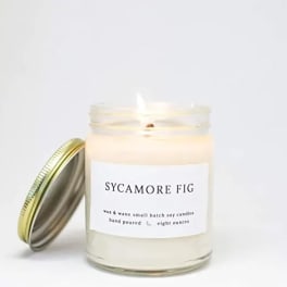 A scented candle in a glass jar with a metal lid