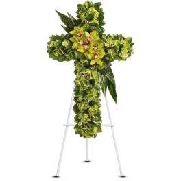 Green floral cross with hydrangeas and orchids on a white metal easel