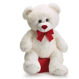 White teddy bear with a red bow sitting on a red box