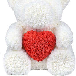 White teddy bear holding a red heart made of roses