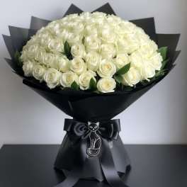 Bouquet of white roses wrapped in black paper with a cat ribbon charm