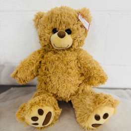 Plush teddy bear sitting on a light surface