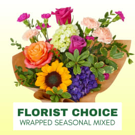 Mixed bouquet with roses, sunflower, hydrangea, and carnations wrapped in brown paper