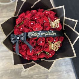 Red rose bouquet with black wrapping, ribbon, and butterfly decorations