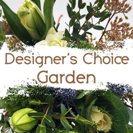 Garden-style floral arrangement with pale green blooms and dark foliage