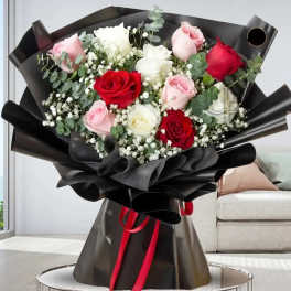 Bouquet of red, pink, and white roses wrapped in black paper