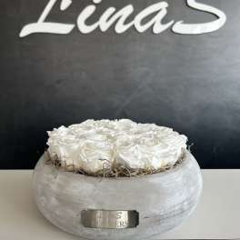 White roses arranged in a round gray container