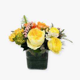 Yellow and orange rose arrangement in a square glass vase