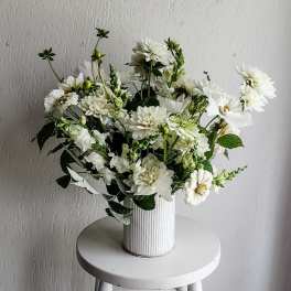 White flower arrangement in a ribbed white vase