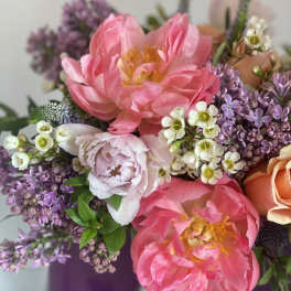 Pink peonies and purple lilacs in a vase