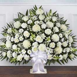 Large white floral standing spray with roses and daisies on a white easel