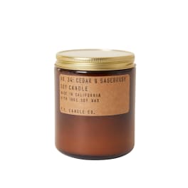 Brown glass candle jar with a gold lid and label