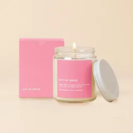 Lit candle in a glass jar with a pink box and lid