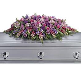 Lavender and pink floral casket spray on a silver casket