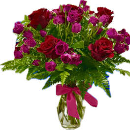 Red roses and pink spray roses in a glass vase with a ribbon