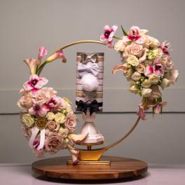 Two floral arrangements with roses and calla lilies on a decorative stand