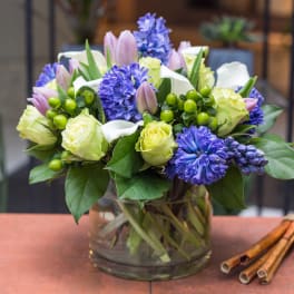 Bouquet of purple and pale yellow flowers in a glass vase