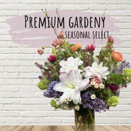 Mixed bouquet of white, pink, purple, and orange flowers in a glass vase