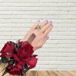 Red rose wrist corsage with black ribbon and silver accents