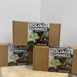 Three cardboard boxes of foliage funnels stacked on a round pedestal.