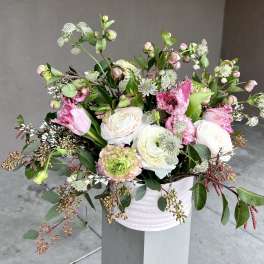 Loose bouquet of pink and white flowers in a pale vase