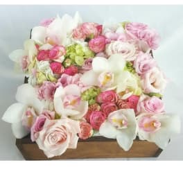 Pink and white floral arrangement in a wooden box