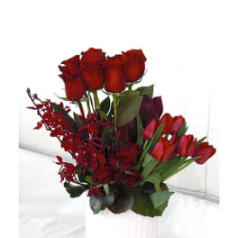 Red roses and tulips arranged in a white vase