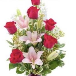 Red roses and pink lilies arranged in a purple vase