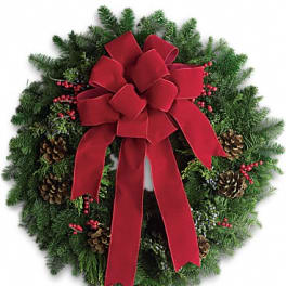 Evergreen holiday wreath with a large red bow and pinecones