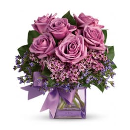 Bouquet of lavender roses with purple filler in a square glass vase