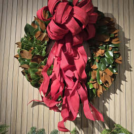 Decorative wreath with a large red ribbon bow
