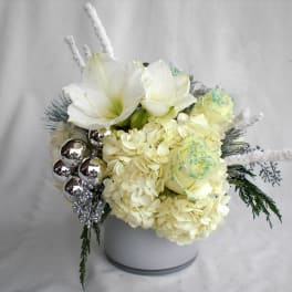 White floral arrangement with hydrangeas and roses in a white vase