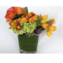 Orange roses and yellow tulips in a green vase