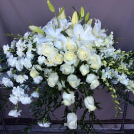 White roses and lilies arranged in a large spray