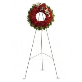 Red floral wreath on a metal easel stand