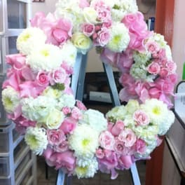 Pink and white floral wreath on a stand