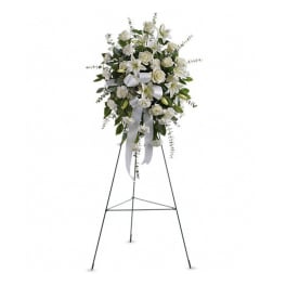 White floral standing spray on an easel with ribbon