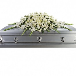 White floral casket spray on a silver casket