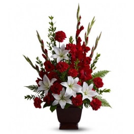 Red carnations and white lilies in a dark vase