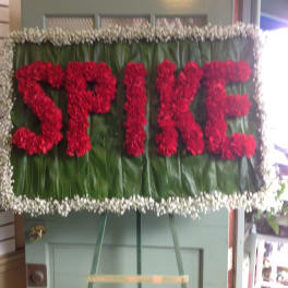 Red floral spray spelling "SPICE" on a green leaf background
